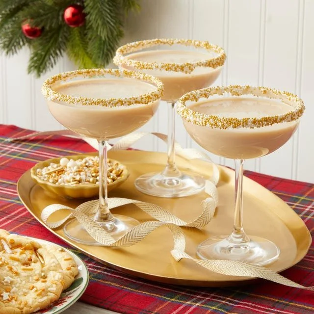 A Sugar Cookie Martini garnished with festive sprinkles and a cookie.